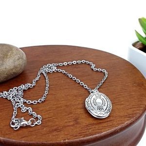 Oval locket charm and silver tone chain ne…